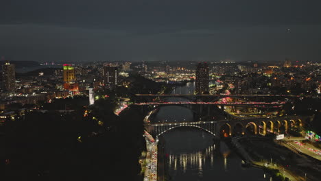 NYC-New-York-Aerial-v263-drone-flyover-Harlem-river-capturing-bridges-crossings,-peak-hours-traffic-and-night-cityscape-of-Highbridge-in-Bronx-at-dusk---Shot-with-Inspire-3-8k---September-2023