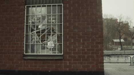 Shattered-and-destroyed-window-after-a-burglary,-snowing-winter,-handheld