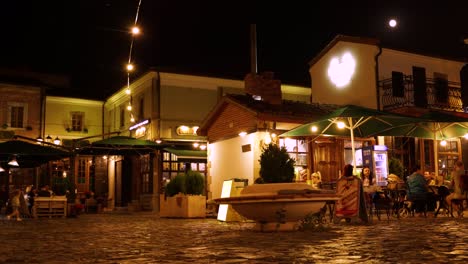 Old-city-square-in-Korca,-Albania-with-traditional-houses-and-bar-restaurants-at-night