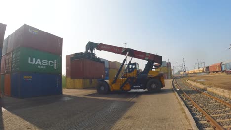 Ein-Kran,-Der-Einen-Großen-Lagercontainer-Auf-Einen-Lastwagen-In-Einem-Trockenzug-Eisenbahnhafen-In-Madhya-Pradesh,-Indien,-Lädt