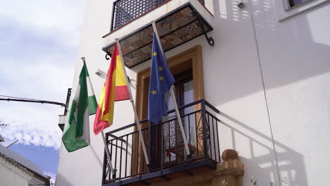 Kosta-Del-Solo,-Bandera-De-La-Unión-De-España-Y-Europa-Ondeando-En-El-Lado-Del-Edificio