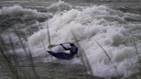 Local-student-paddler-trying-to-surf-and-do-tricks-on-a-big-wave-on-river-Nile,-Jinja-Uganda