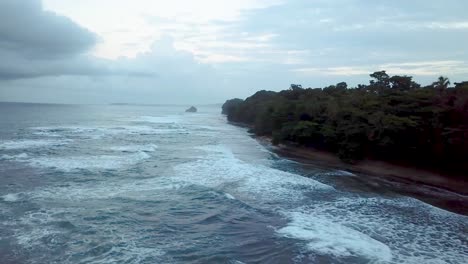 Luftaufnahme-Eines-Fluges-über-Und-Weg-Von-Einem-Stürmischen-Karibischen-Meer-In-Der-Abenddämmerung-In-Puerto-Viejo-De-Talamanca-In-Costa-Rica