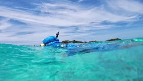 Man-snorkeling-swimming-underwater-surface,-with-mask-and-hood,-crystal-sea-Los-Roques