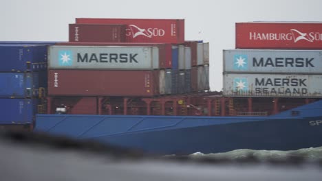 A-stationary-footage-of-a-fast-container-ship-passing-by-across-the-sea