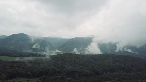 Drone-flying-up-over-forest-and-trees-in-the-Smoky-Mountains,-USA-into-the-cloudy-sky-for-an-incredible,-gorgeous-scene