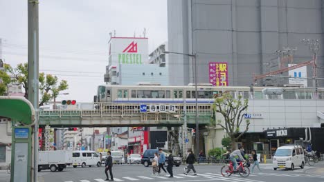 Pan-from-left-to-right-as-Japanese-train-departs-station-in-Osaka-city