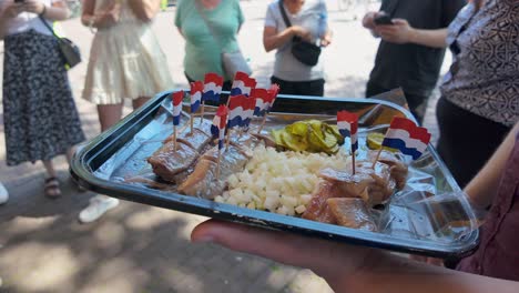 Raw-Herring,-onions,-and-pickles-in-Amsterdam,-Netherlands