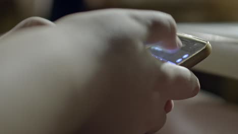 Close-up-shot-of-a-person's-hand-holding-a-phone-and-typing-on-it