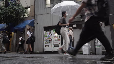 La-Gente-Pasa-Junto-A-Las-Máquinas-Expendedoras-En-Tokio-En-Un-Día-Lluvioso.