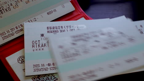 Placing-Japan-Rail-Pass-reservation-tickets-on-a-table-on-top-of-Wallet,-21-day-pass-system-tickets