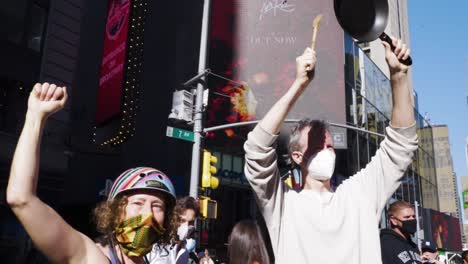 A-white-couple-in-New-York-City-bangs-a-pot-amid-celebrations-in-Times-Square-after-it-is-announced-that-Joe-Biden-won-the-2020-Presidential-Election