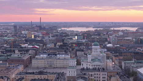 Absteigende-Drohnenaufnahme-Mit-Blick-Nach-Westen-über-Helsinki-Bei-Sonnenuntergang-Mit-Blick-Auf-Die-Kathedrale