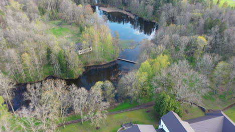 Toma-Panorámica-De-Un-Dron-De-La-Mansión-Jaungulbene-En-Un-Exuberante-Paisaje-Letón-En-Una-Vista-Aérea-Reveladora