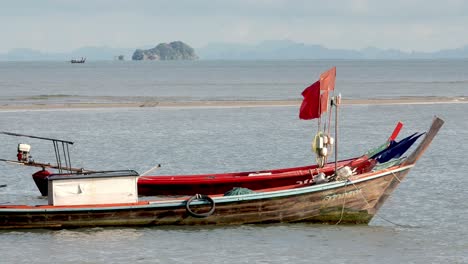 Blick-Auf-Fischerboote,-Die-Tagsüber-An-Einem-Windgepeitschten-Strand-Im-Süden-Von-Satun,-Thailand,-Festgemacht-Haben