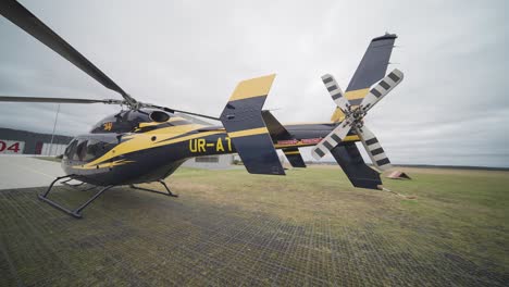 A-Bell-249-helicopter-sits-parked-on-the-grassy-field-at-Vaclav-Havel-Airport-in-Prague,-ready-for-its-next-flight