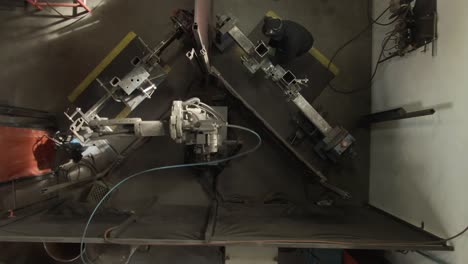 4K-footage-overhead-shot-of-robot-machine-welding-with-man-working-beside-it