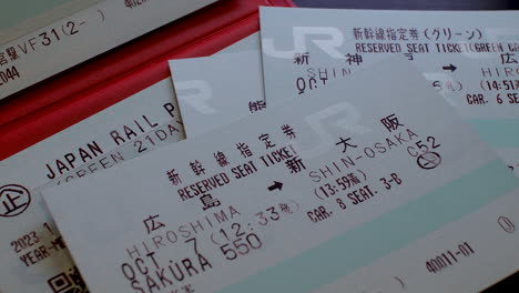 Japan-Rail-Pass-Shinkansen-Tickets-Auf-Einer-Roten-Reisebrieftasche-Auf-Dem-Tisch-Stapeln