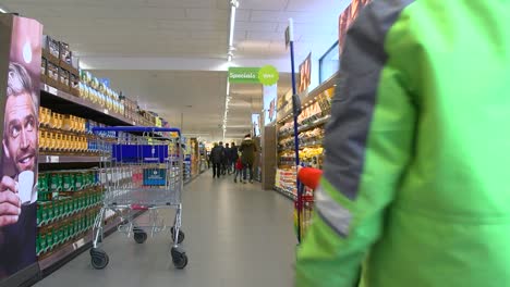 Mother-and-son-walking-in-grocery-store,-while-the-mum-is-looking-for-products