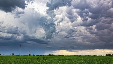 Dark-storm-clouds-and-rainfall-flow-over-rural-landscape,-time-lapse-view