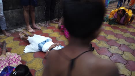 Foto-De-Una-Mujer-Realizando-El-Ritual-De-Chatt-Puja-Cruzando-A-Los-Niños-En-El-Templo-De-Kolkata.