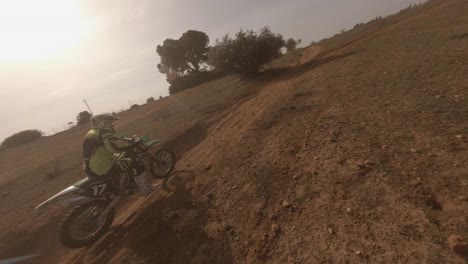 Dynamic-FPV-drone-flying-tracks-motorcycle-rider-on-sandy-dirt-trail