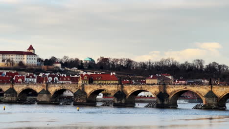 This-panoramic-video-captures-Charles-Bridge-from-across-the-Vltava-River-in-Prague,-featuring-trees-and-flying-seagulls,-highlighting-the-city's-natural-beauty-and-historic-charm