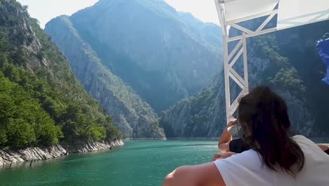 Zwei-Mädchen-Fotografieren-Einen-Canyon,-Während-Sie-Auf-Einem-Boot-Auf-Einem-Fluss-Fahren