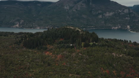 Zoom-in-to-cottage-in-the-middle-of-forest-with-lake-in-background