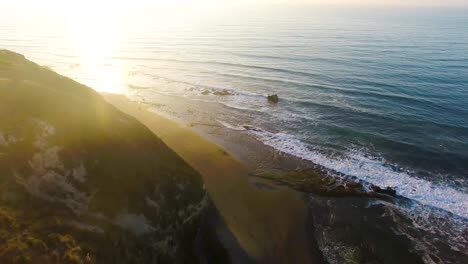 Sunset-on-beach-near-cliff-area-at-Matanzas,-Navidad-region-in-the-south-of-Chile