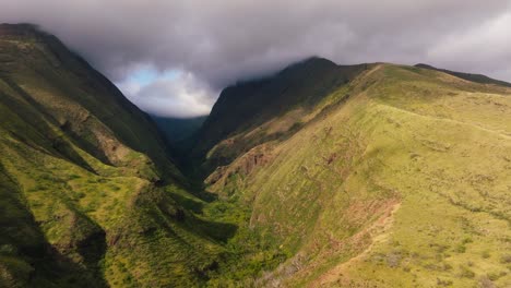 Breathtaking-aerial-view-of-lush-green-valleys-and-rugged-mountains-on-a-cloudy-day-in-Maui