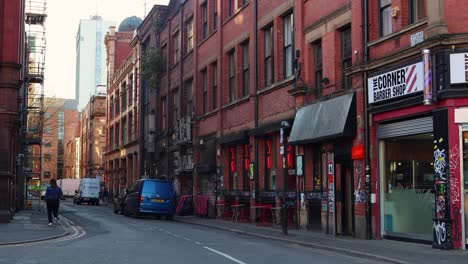 Calle-Vibrante-En-El-Barrio-Norte-De-Manchester-Con-Edificios-De-Ladrillo-Rojo,-Tiendas-Y-Arte-Callejero.