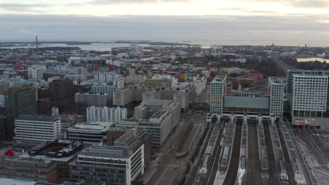 Aerial,-pan,-drone-shot-overlooking-the-Pasila-railway-station-and-the-Mall-of-Tripla-shopping-center,-on-a-partly-sunny-evening,-in-Helsinki,-Finland