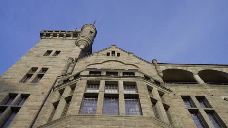 Camera-panning-up-from-two-people-walking-on-a-castle-with-blue-sky