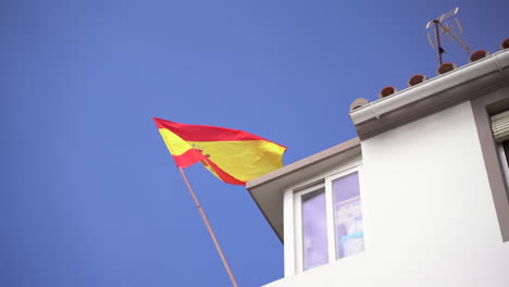 Bandera-Española-Ondeando-En-Lo-Alto-De-Un-Edificio-Blanco-En-Estepona,-Vista-Estática