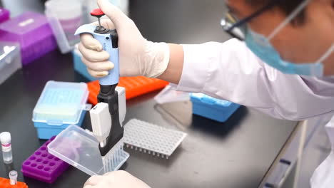 Chemist-professional-laboratory-technician-in-a-white-lab-coat-doing-something-with-a-glass-doing-medical-research-test-tube-experiments