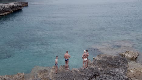 Lustige-Familie,-Die-Spaß-Hat-Und-An-Einem-Felsigen-Strand-Angelt