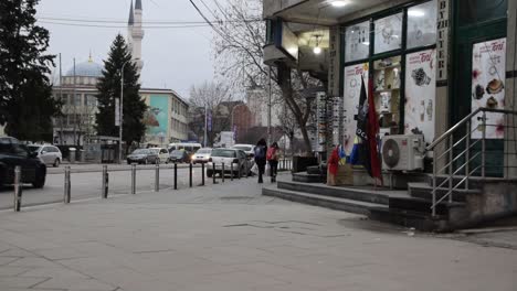 Schoolgirls-walking-past-shop-that-sells-kosovar-and-Albanian-flags-in-Mitrovica