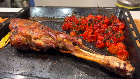 Deliciosa-Pierna-De-Cordero-Asada-Con-Tomates-Cherry,-Carne-Tierna-Y-Tierna-Cocinada-En-El-Horno,-Toma-De-4k