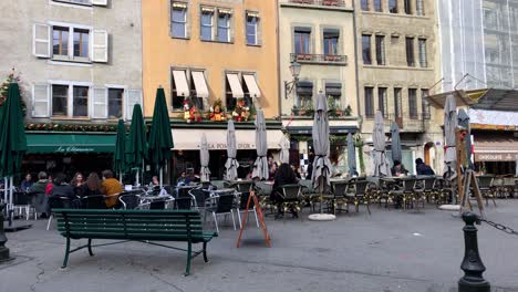 People-having-lunch-at-the-terrace-of-a-restaurant-downtown-Geneva-in-Switzerland