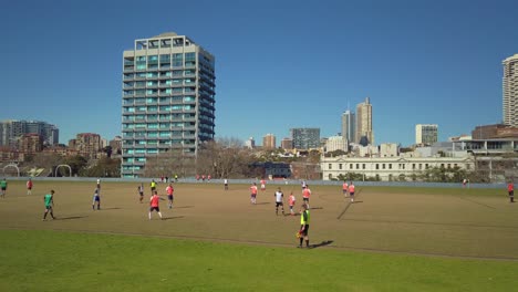 Trabajadores-Profesionales-De-Oficina-Jugando-Fútbol-Durante-El-Almuerzo-En-Un-Parque-Para-Liberar-Estrés