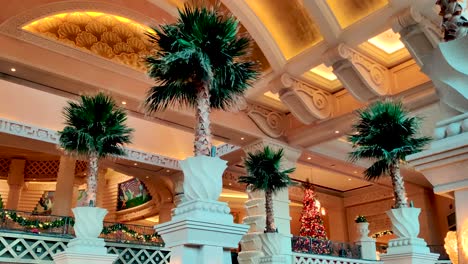 Luxury-stylish-interior-of-hotel-Atlantis-in-Bahamas-with-palm-trees,-motion-view,-panning-shot-inside-a-shopping-center