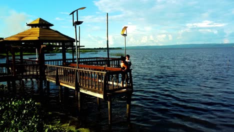 Madre-E-Hijo-Disfrutando-De-Una-Hermosa-Puesta-De-Sol-En-El-Lago-Ypacarai-En-La-Ciudad-De-Aregua,-Paraguay