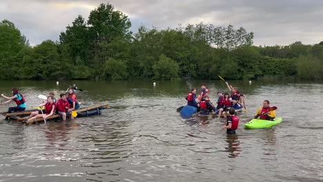 people-riding-on-home-made-rafts-that-they-made-from-barrels,-logs-and-ropes