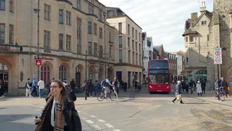 Busy-crowds-of-pedestrians-walking,-cyclist-and-public-transport-in-the-city-centre-of-Oxford,-England-UK