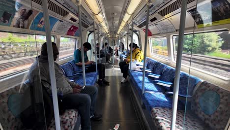 View-Looking-Along-Inside-Carriage-Of-Moving-Jubilee-Line-Train-On-Sunny-Afternoon