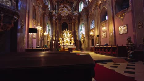 Believers-in-the-pews-sing-along-with-the-priest-sitting-at-the-gold-decorated-altar,-Bazilica-Minore-Navštívení-Panny-Marie-na-Svatém-Kopečku