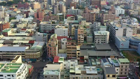 Vistas-Aéreas,-Drones-Sobrevuelan-El-Vecindario-Hacia-El-Centro-De-La-Ciudad-De-Douliu-Capturando-Edificios-Residenciales-Y-Comerciales-Y-Un-Tren-Que-Sale-De-La-Estación-Principal,-Condado-De-Yunlin,-Taiwán