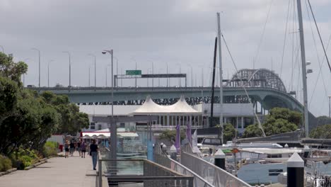 People-walking-on-street-of-Auckland-near-harbour-bridge,-New-Zealand