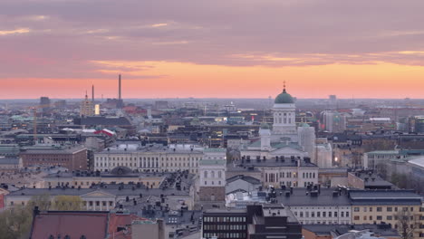 Westward-aerial-view-over-city-at-sunset-with-Helsinki-Cathedral-in-foreground